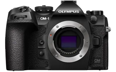 Czarny aparat OM-1 z metalowym bagnetem i logo OM SYSTEM.