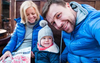 Rodzina zwiedza Lwów na Ukrainie. Uśmiechnięci rodzice i dziecko z mapą.