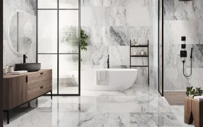 Elegantes combinaciones de azulejos para baños con efecto mármol, bañera exenta y mueble de madera.