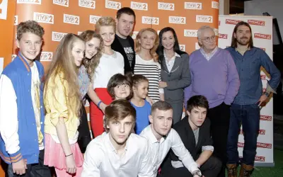 Rodzinka.pl obsada: młodzi i starsi aktorzy pozują do zdjęcia. W tle logo TVP 2 i rodzinka.pl.