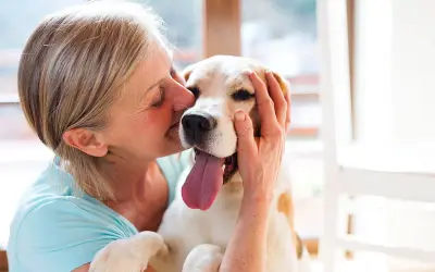 Une femme câline son chien, un moment de pur bonheur. Une véritable cure thermale avec chien pour le bien-être de tous.