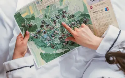 Dłoń wskazuje na mapę z zaznaczonymi atrakcjami turystycznymi.