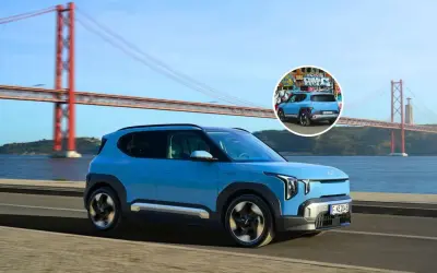 El ev2 Kia azul, con un diseño moderno, cruza un puente icónico. En un círculo, se ve su parte trasera con grafitis.