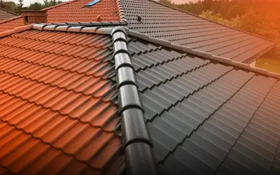 Dach z połową pomalowaną na ciemno, a połową w naturalnym kolorze dachówki.