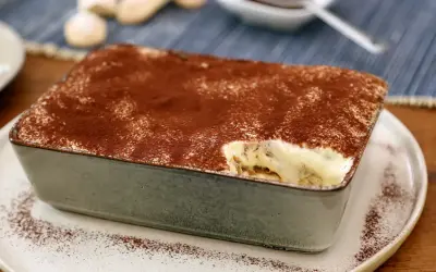 Un délicieux tiramisu pour 4 personnes, saupoudré de cacao, prêt à être dégusté.