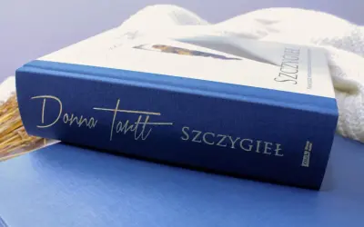 Granatowa okładka książki "Szczygieł" Donny Tartt z wytłoczonym złotym napisem.