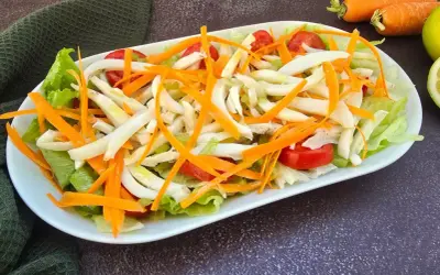 Deliziosa insalata di seppie con lattuga croccante, carote julienne e pomodorini freschi. Un piatto leggero e saporito.