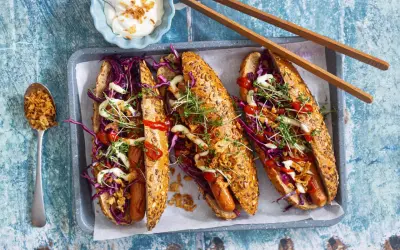 Drei leckere Hotdogs mit Rotkohl, Kresse und Röstzwiebeln – perfekt für vegetarisches Grillen!