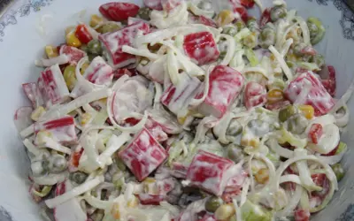 Pyszna sałatka z paluszkami surimi, groszkiem, kukurydzą i porem, polana kremowym sosem.