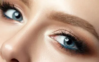 Nahaufnahme eines blauen Auges mit braunem Lidschatten und blauer Eyeliner-Linie. Perfekt für die Frage: welche haarfarbe bei blauen augen.
