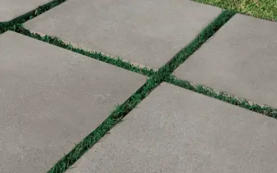 Percorso moderno con piastrelle da esterno 2 cm grigie, alternate a strisce di erba verde.