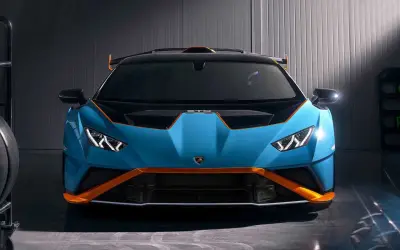 Niebieski Lamborghini Huracan STO z pomarańczowymi akcentami, gotowy do wyjazdu na tor.