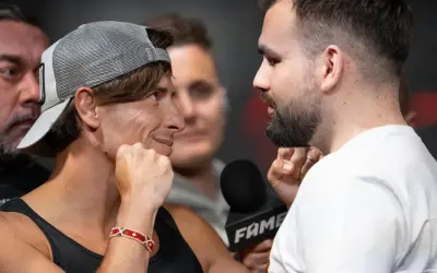 Dwóch zawodników na Fame MMA 30, jeden w czapce z daszkiem, drugi z brodą, patrzą na siebie z napięciem.