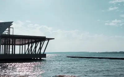 Nowoczesna architektura nad jeziorem Niegocin. Widok na wodę i niebo z chmurami. Atrakcje turystyczne Mazur.