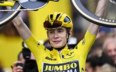 Jonas Vingegaard im Gelben Trikot, mit seinem Rad über dem Kopf. Sein Gehalt ist wohl hoch, bei diesem Erfolg!
