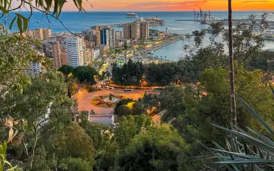 Zachód słońca nad Malagą. Widok na port, miasto i plac z fontanną. Idealne miejsce, by zobaczyć, co oferuje Malaga.