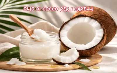 Olio di cocco per capelli: scopri le sue incredibili proprietà. Un vasetto di olio di cocco, un cocco aperto e foglie verdi.