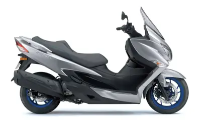 Elegancki, srebrny Suzuki Burgman Executive z niebieskimi akcentami na siedzeniu i felgach.