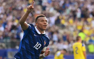 Kylian Mbappé, młody piłkarz, świętuje bramkę. Ile lat ma Mbappé? W tym momencie ma 25 lat.