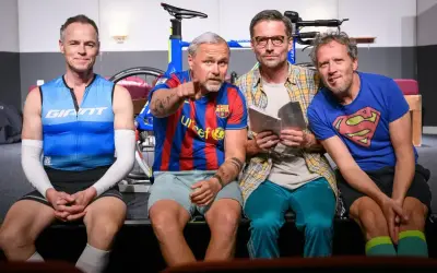 Chłopaki z żelaza, czyli bohaterowie triathlon story, siedzą obok siebie. Jeden w koszulce Supermana, drugi w barwach Barcelony, gotowi na wyzwania.