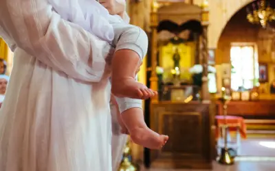 Dziecko w kościele, czy rodzic może być świadkiem bierzmowania? W tle ołtarz i ikony.