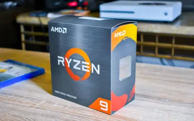 AMD Ryzen 9 5900X Box, bereit für den Test. Daneben liegt ein Blu-ray-Spiel.