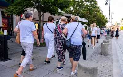 Grupa kobiet po 60-tce spaceruje po mieście. Być może rozmawiają o możliwościach, jakie daje stały zasiłek dla bezrobotnych po 60 roku życia.