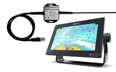 Un boîtier Digital Yacht iKonvert pour branchement NMEA 0183 et NMEA 2000, connecté à un écran Raymarine affichant une carte marine.
