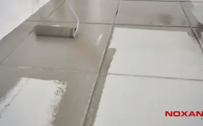 Wałek maluje podłogę z płytek, nadając jej matowe wykończenie. Dowiedz się, jak zmatowić płytki.