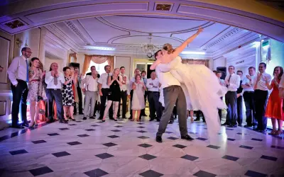 Para młoda wiruje w tańcu, goście patrzą z zachwytem. To piękny moment, jak bachata taniec.