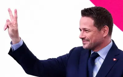 Rafał Trzaskowski pokazuje dwa palce, symbolizując zwycięstwo.