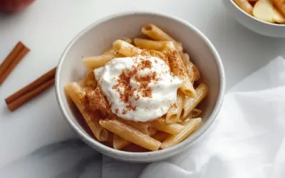 Penne makaron z jabłkami, polany śmietaną i posypany cynamonem. Aromatyczny deser, który zachwyca smakiem.