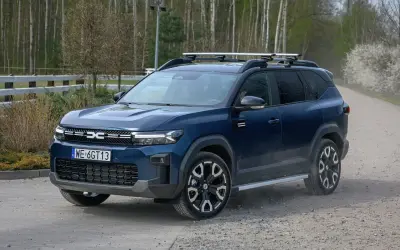 Ciemnoniebieski SUV z bagażnikiem dachowym, idealny na podróże. To najlepsze auto na gaz, gotowe na każdą drogę.