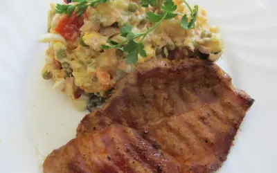 Ein saftiges Schweinefilet mit einem bunten spanischen Salat, garniert mit Petersilie.
