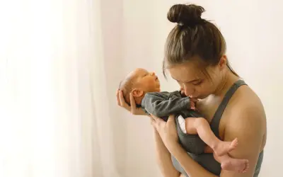 Madre abraza a su bebé recién nacido. La ternura en sus miradas hace olvidar cuánto dura la cuarentena.