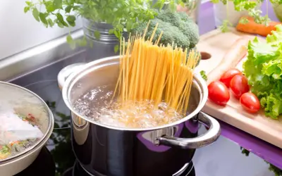 Spaghetti kochen in sprudelndem Wasser. Daneben frisches Gemüse wie Brokkoli, Karotten und Tomaten. So einfach ist es, wie koche ich nudeln!