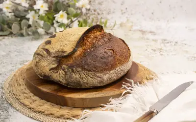 Pan artesanal de masa madre, dorado y crujiente, listo para disfrutar. El arte de hacer pan con masa madre.