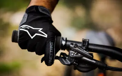Mano enguantada con logo Alpinestars en manillar de bici. ¡Ya me duermen las manos en la bici!