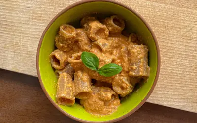 Rigatoni conditi con un cremoso pesto con mandorle, guarniti con basilico fresco.
