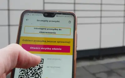 Dłoń trzyma telefon z widocznym kodem QR InPost. Aplikacja pokazuje opcję otwarcia skrytki zdalnie.