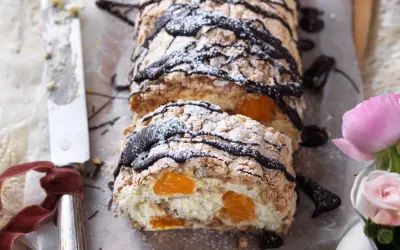 En läcker budapestbakelse med vispgrädde, frukt och chokladdrizzle, pudrad med florsocker.