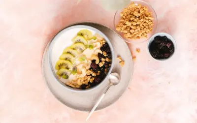 Gesunder Joghurt-Bowl mit Kiwi, Beeren, Nüssen und Granola – perfekt für proteinreiche Mahlzeiten.