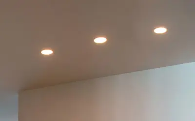 Trois spots encastrés éclairent un plafond. La lampe LED offre des avantages, mais il faut aussi considérer ses inconvénients.