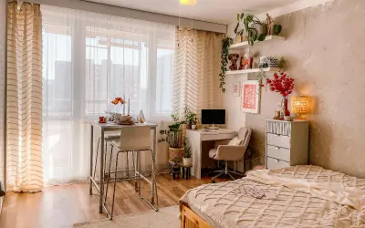 Idee per arredare una casa piccola: un angolo studio, un tavolo alto per mangiare e un letto accogliente, tutto in uno spazio compatto.