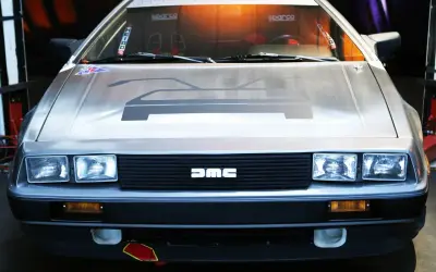 Przód kultowego DeLorean z charakterystycznym logo DMC na grillu.