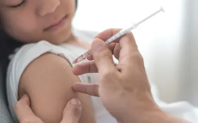Dziecko otrzymuje szczepienie przeciwko polio. Lekarz podaje zastrzyk, chroniąc przed tą groźną chorobą.