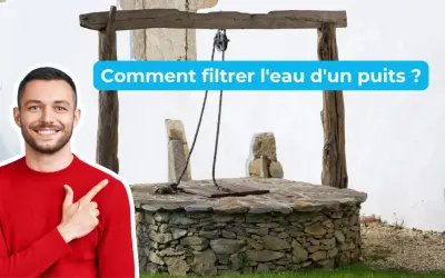 Un homme souriant pointe vers un puits ancien, suggérant des solutions pour le traitement de l'eau de puits.