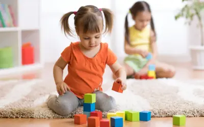Dwie dziewczynki bawią się klockami. Jedna z nich, z kitkami, układa wieżę. To inwestycja w przyszłość, jak 12 tys na dziecko.