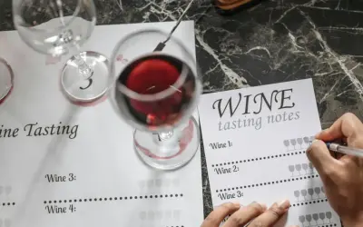 Degustacja wina: kieliszki z czerwonym winem i arkusz notatek do degustacji. Uczymy się, jak degustować wino.