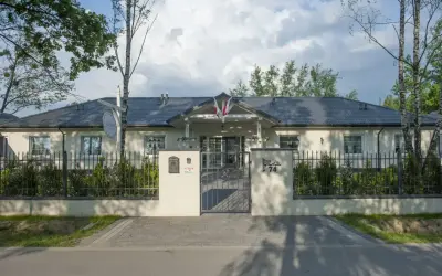 Elegancki lawendowy dom opieki seniora, z pięknym ogrodem i bramą.